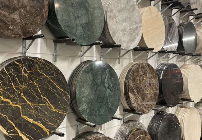 Showroom met collectie ronde marmeren tafelbladen in diverse tinten