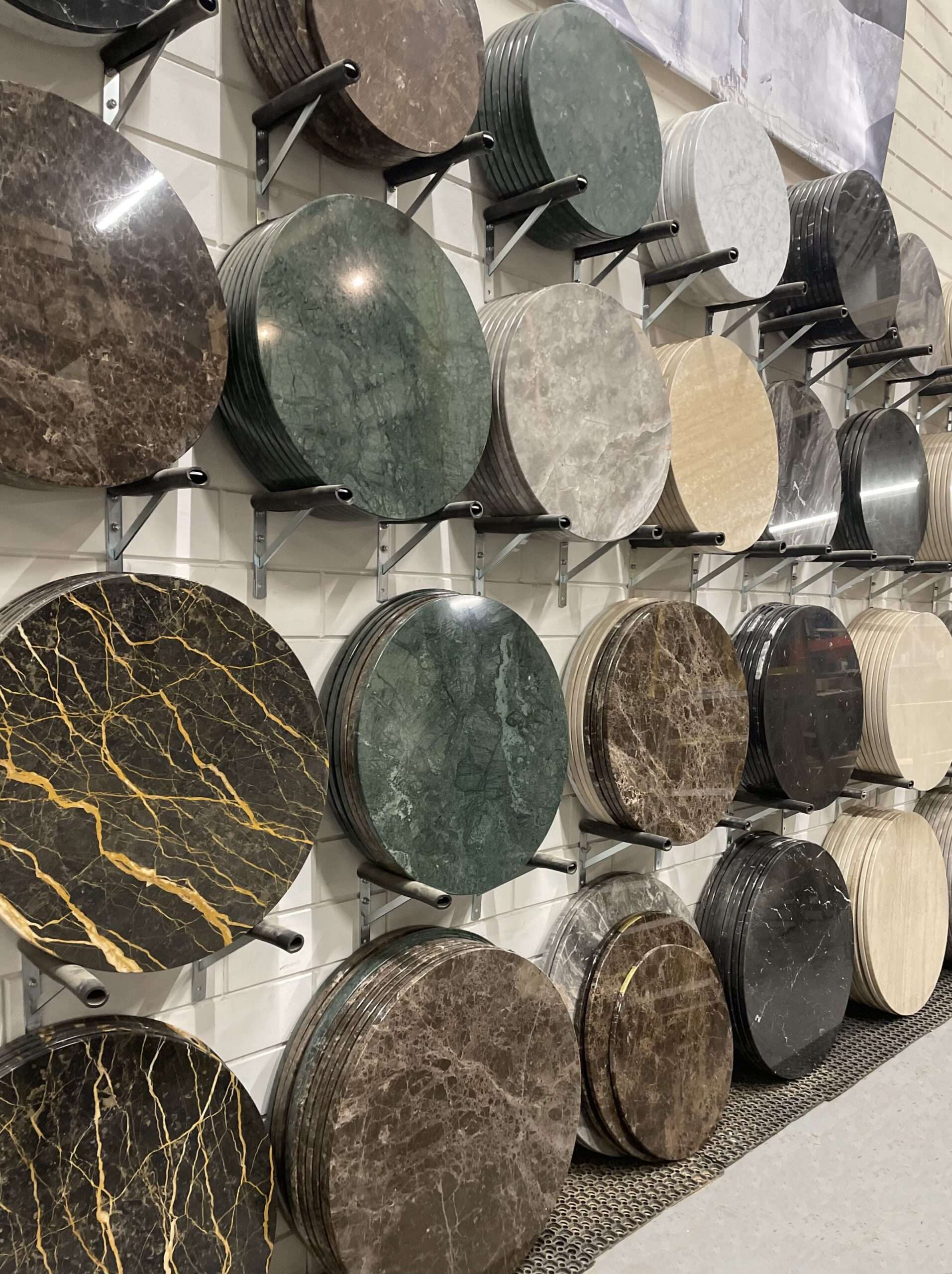 Showroom met collectie ronde marmeren tafelbladen in diverse tinten